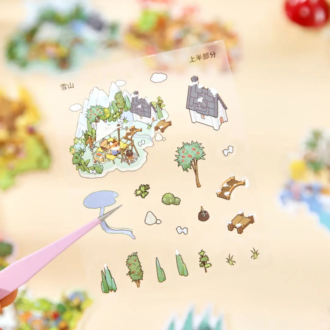 Close-up of a Woodland Town PVC sticker sheet with small forest scene pieces being lifted with tweezers